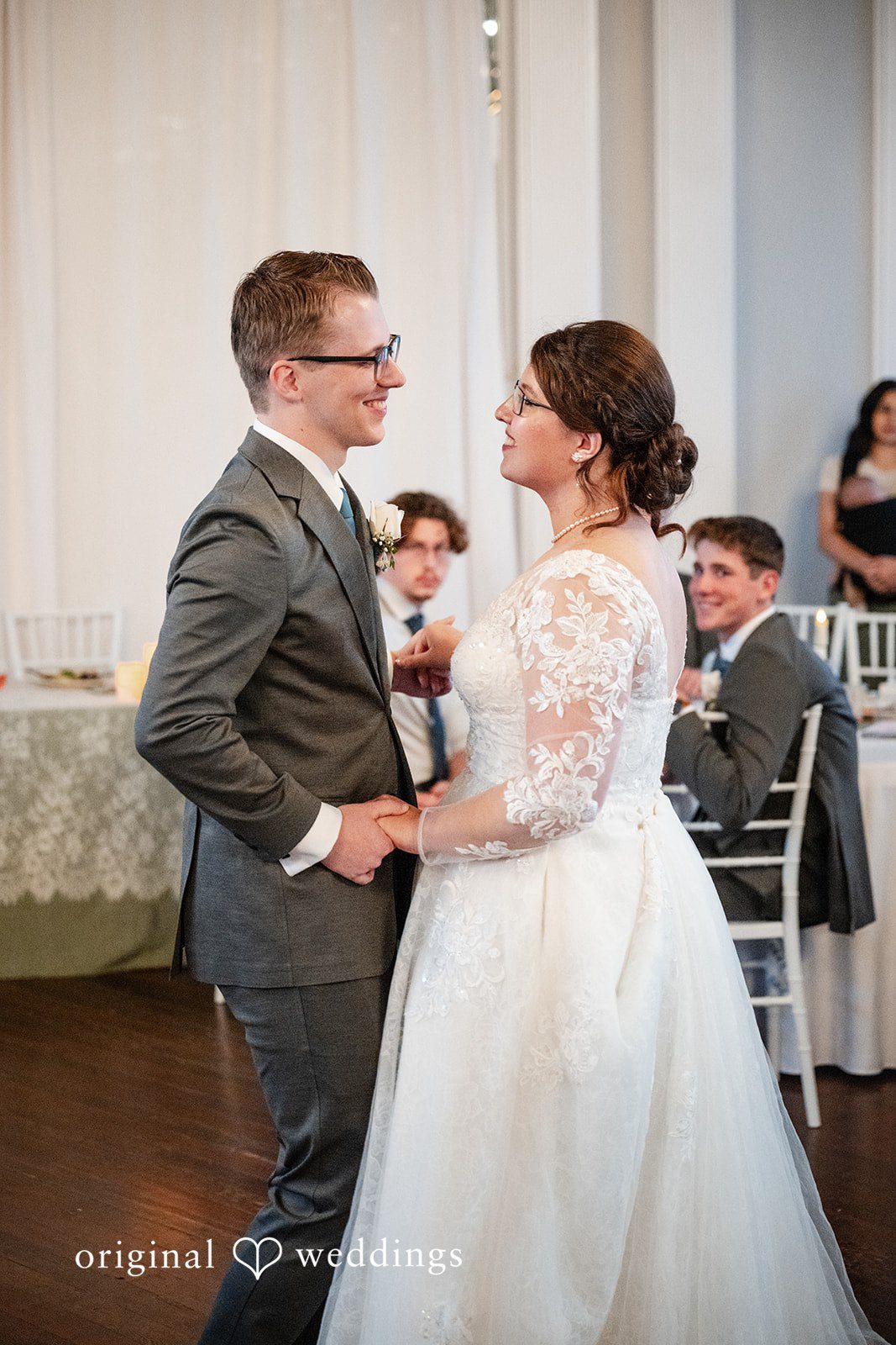 Emma + Aidan A bride and groom holding hands and sharing a dance during their wedding reception.