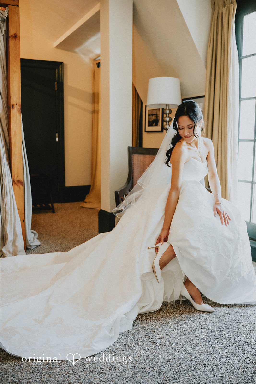 Bride walking down a hallway showing her long dress train.
