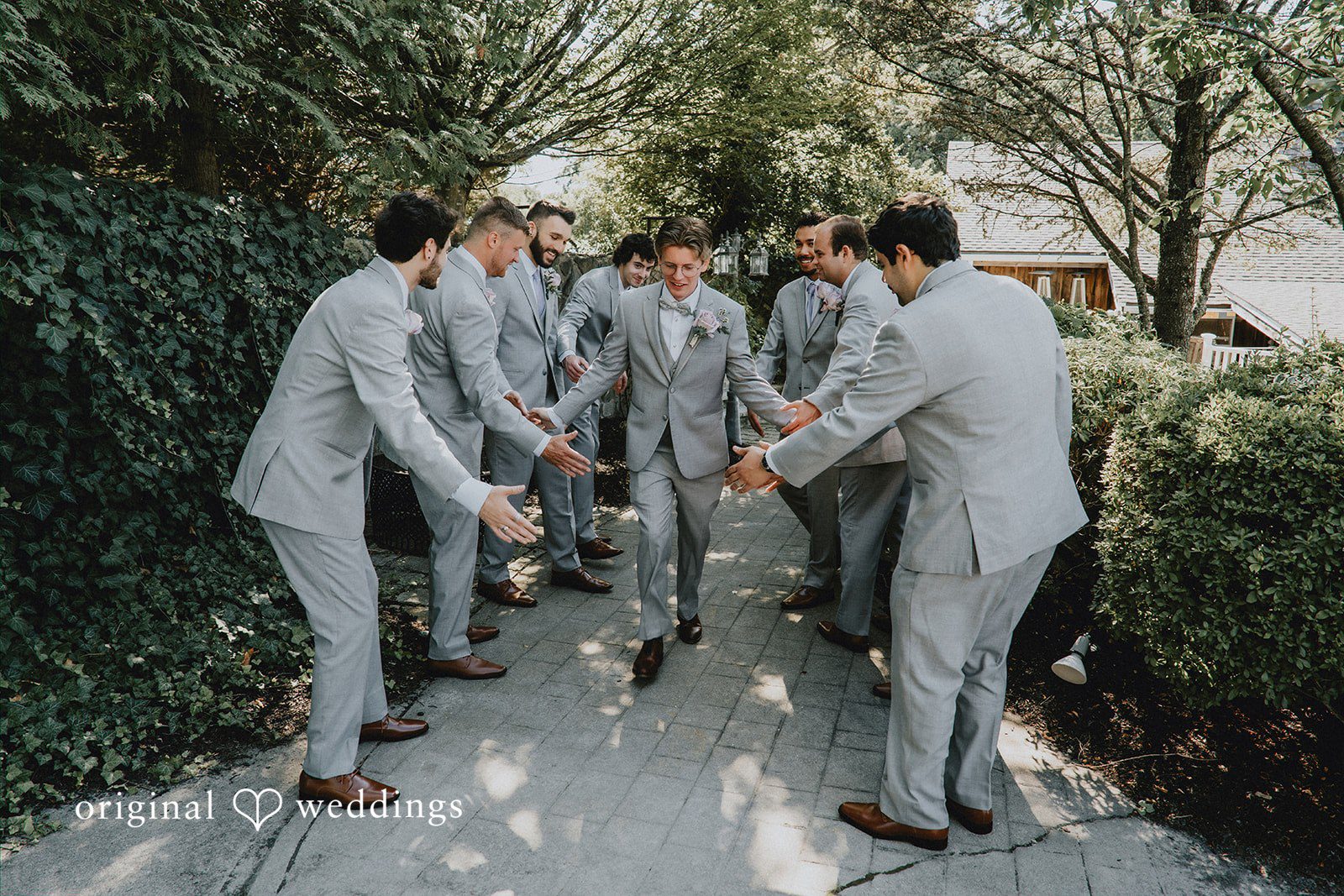 Group of groomsmen walking together in grey suits.