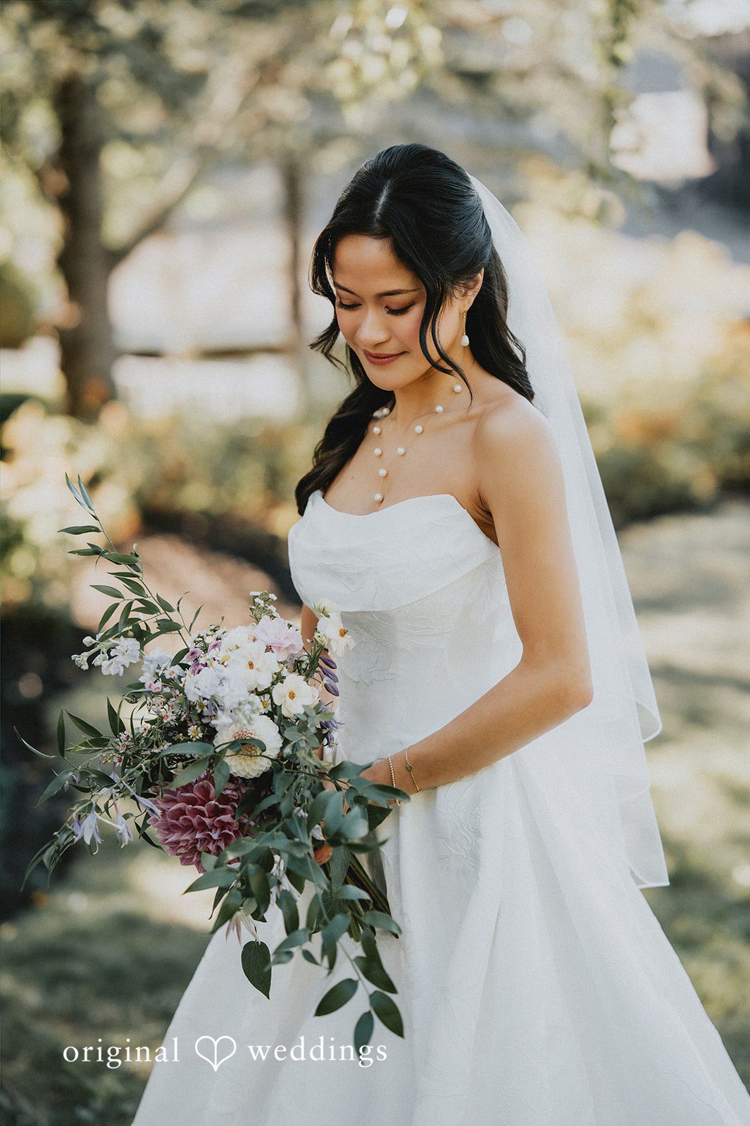 Smiling bride holding a lush green and white bouquet.