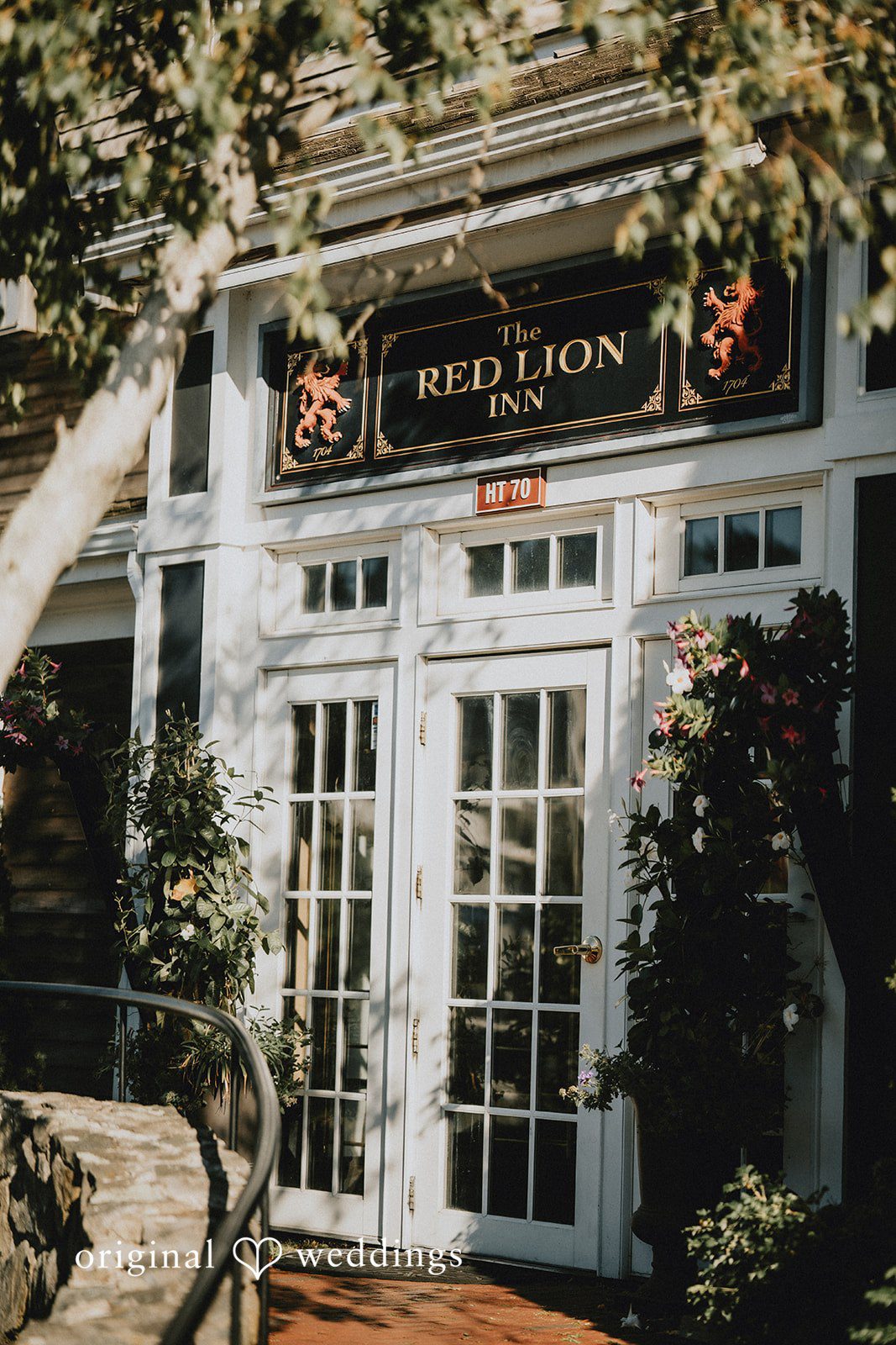 Glass doors of a rustic venue decorated with floral greenery.
