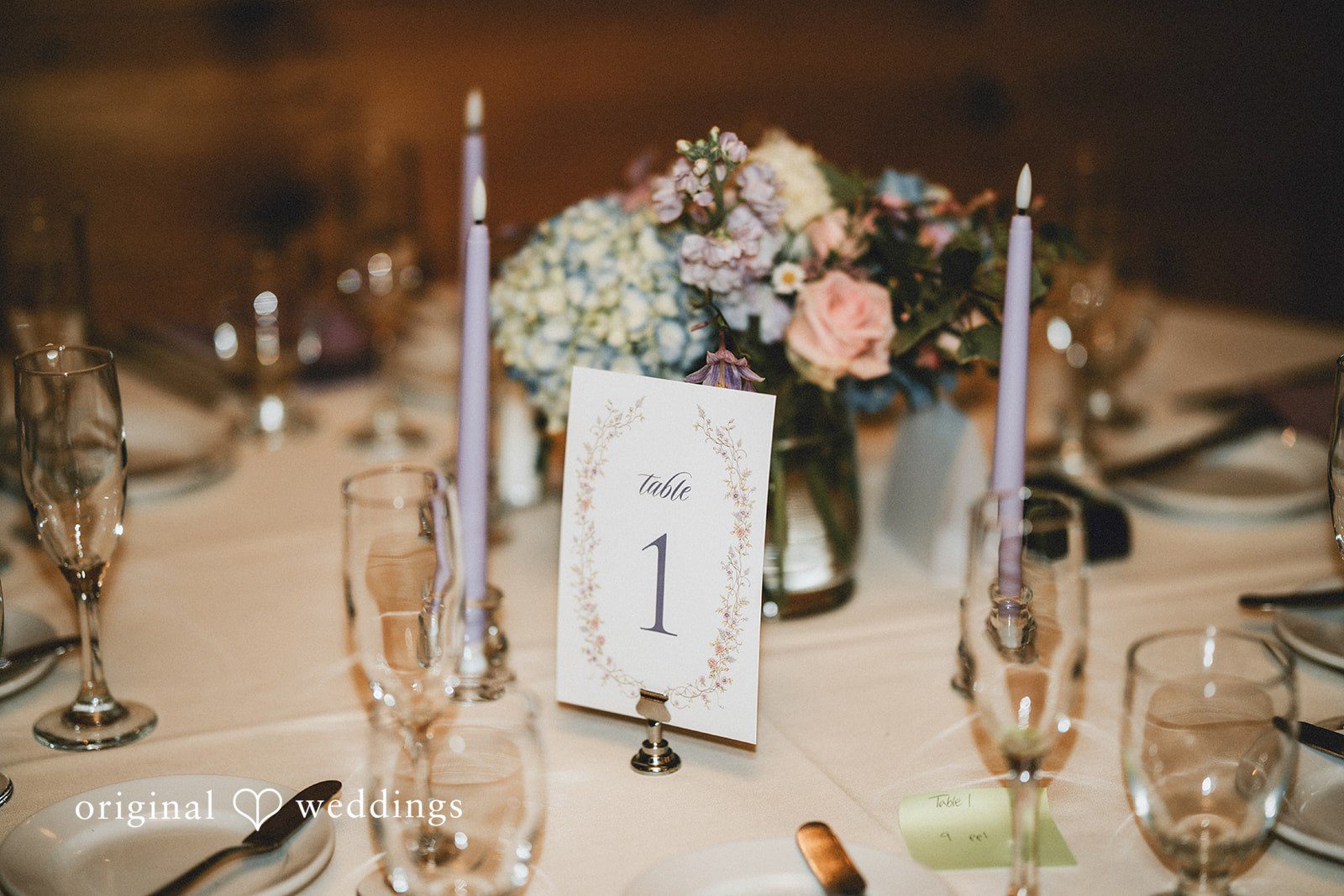 Clear acrylic welcome sign decorated with white flowers.