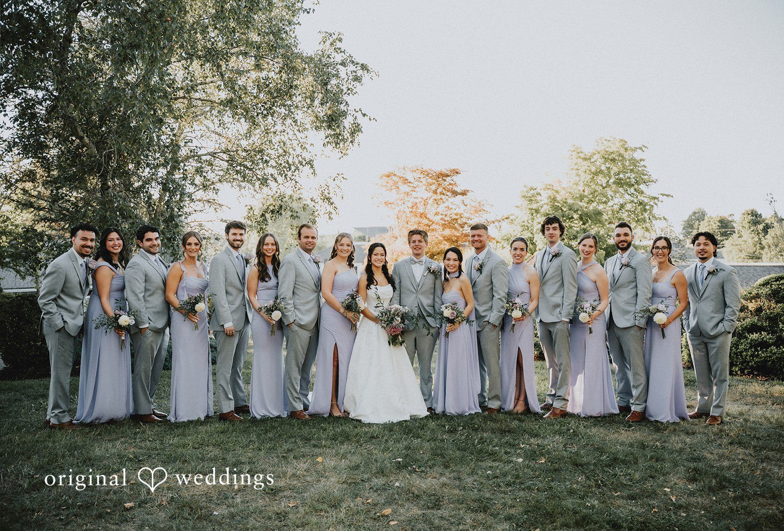 Full bridal party of bridesmaids and groomsmen standing together in a long line at The Red Lion Inn by Boston Wedding Photographers from Original Weddings..