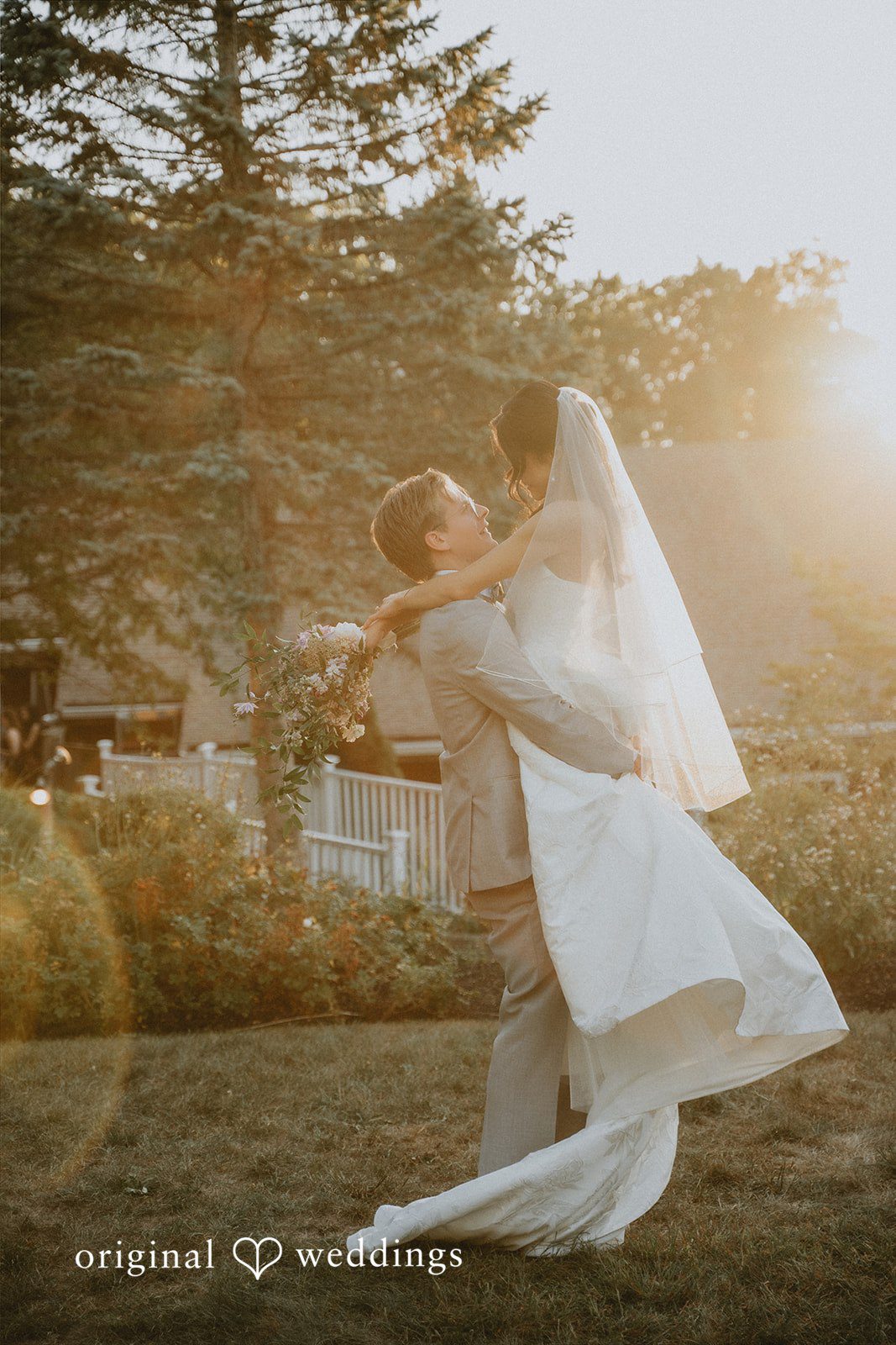 Bride holding a long, flowing white veil that catches the wind.