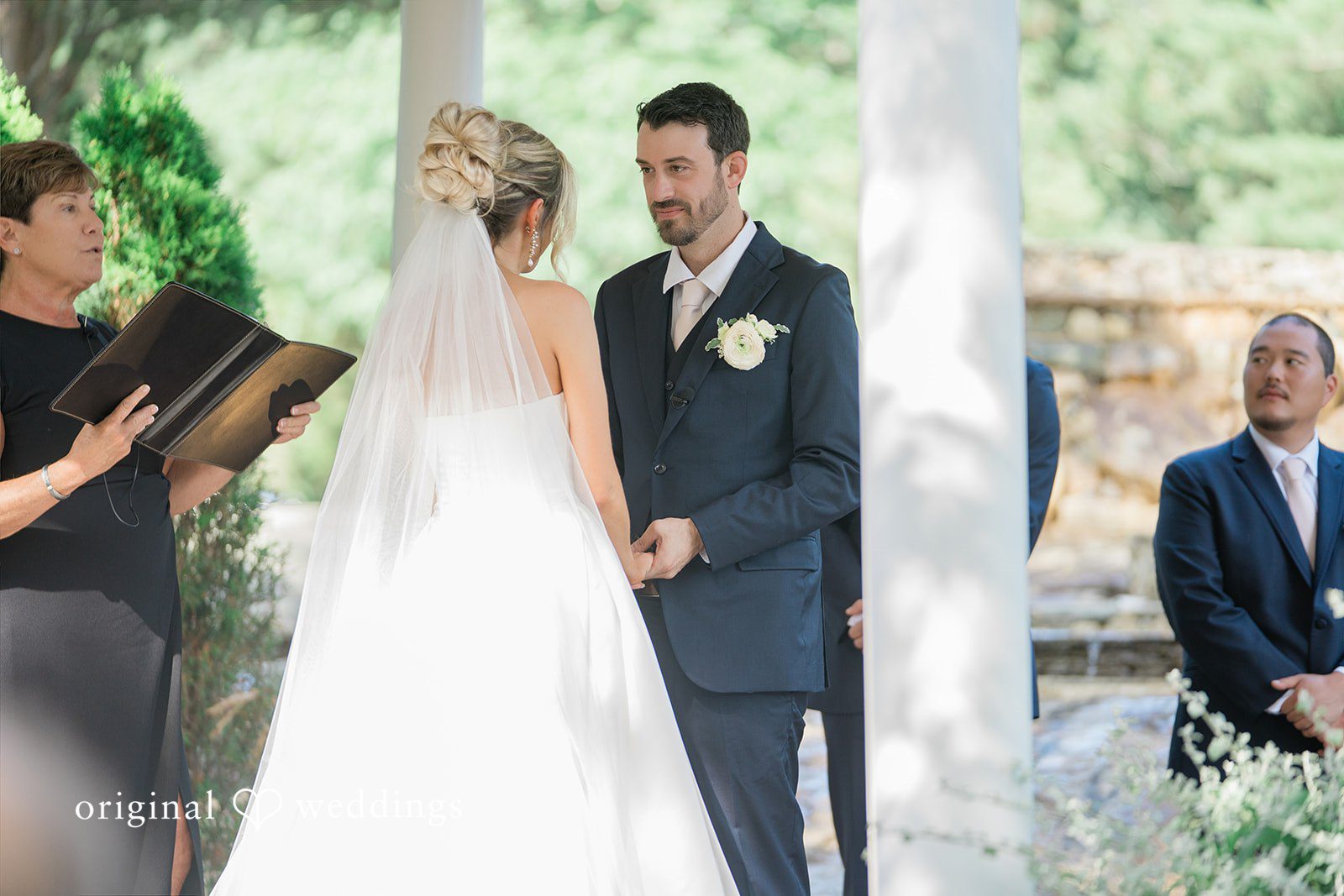 Jessica + Keegan A bride and groom holding hands at the altar during their wedding ceremony.
