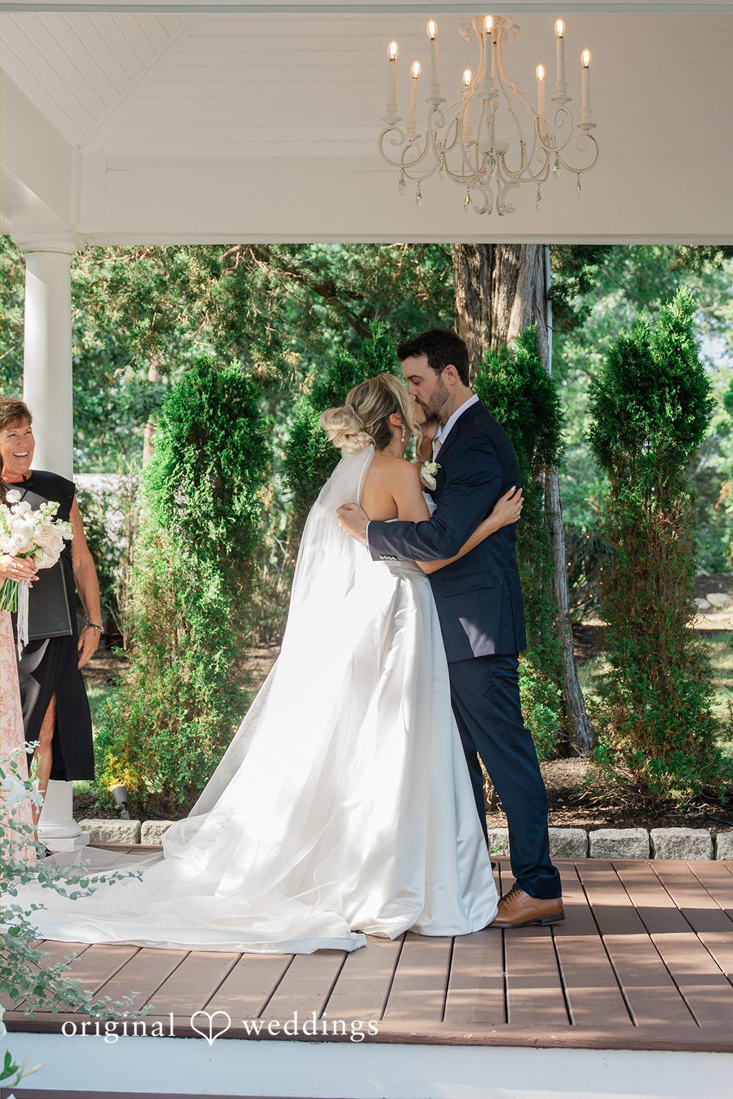 Jessica + Keegan A newly married bride and groom sharing a romantic dip and kiss on a pathway.