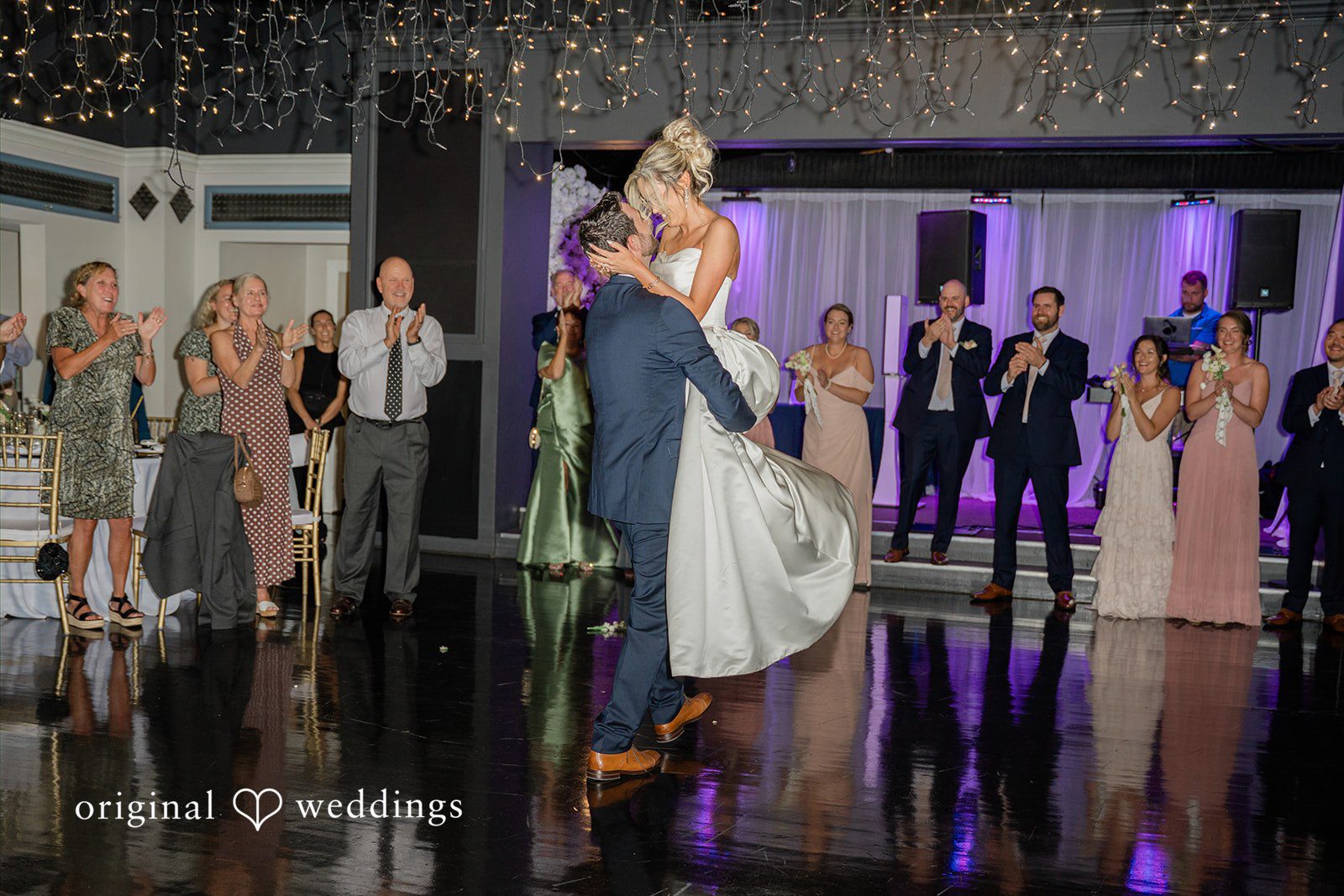 Jessica + Keegan A bride and groom dancing together at their reception surrounded by guest.