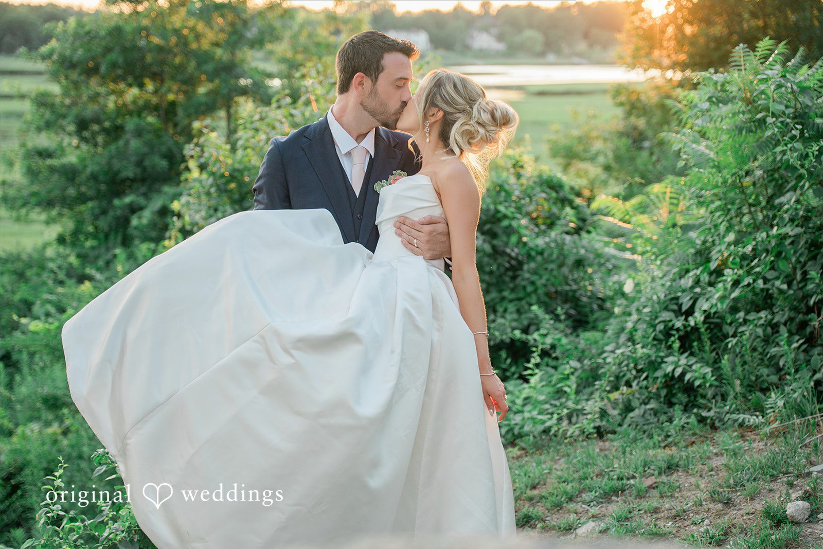 Jessica + Keegan A bride and groom sharing a romantic embrace in a lush green garden setting.