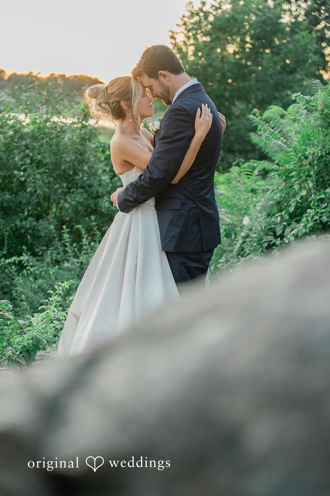 Jessica + Keegan A bride and groom embracing on a grassy hill during a serene moment.