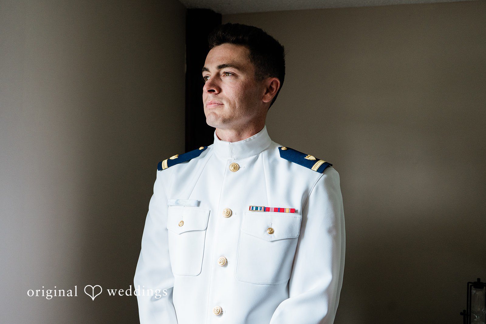 Veronica + Wyatt A groom in a white military dress uniform looking forward.