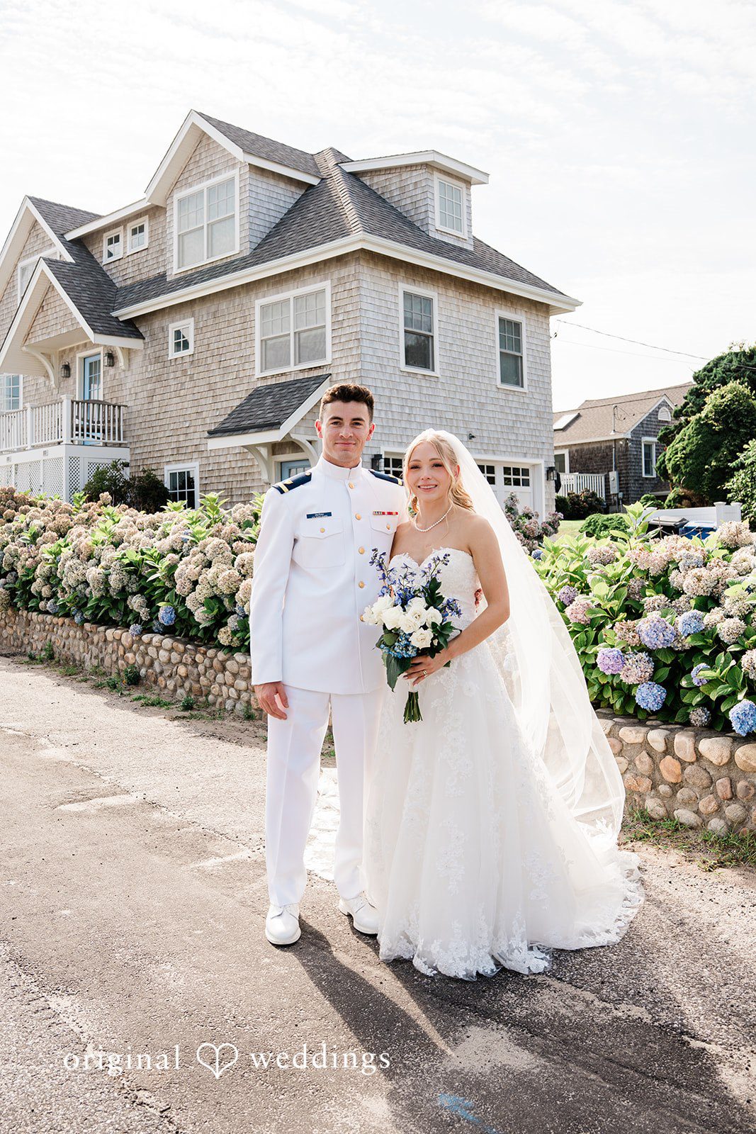 Veronica + Wyatt A bride and groom standing along a pathway next to a house.