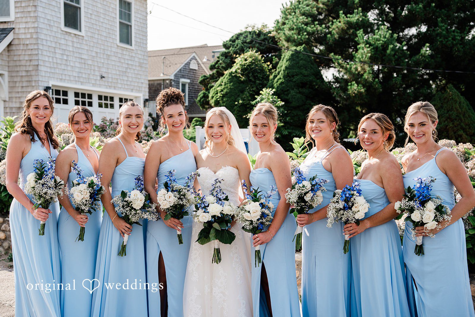 Veronica + Wyatt A wedding party of bridesmaids in light blue gowns holding floral bouquets.