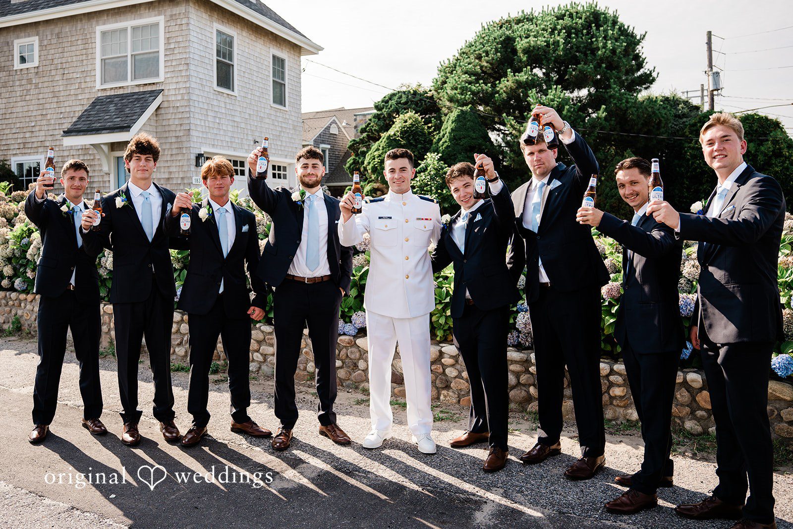 Veronica + Wyatt A large group of groomsmen posing together in dark suits.