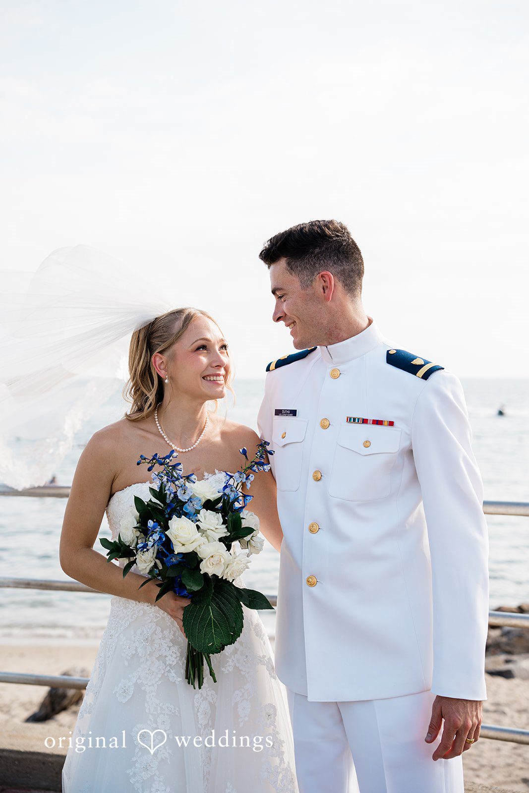 Veronica + Wyatt A bride holding a bouquet next to the groom in a white uniform.