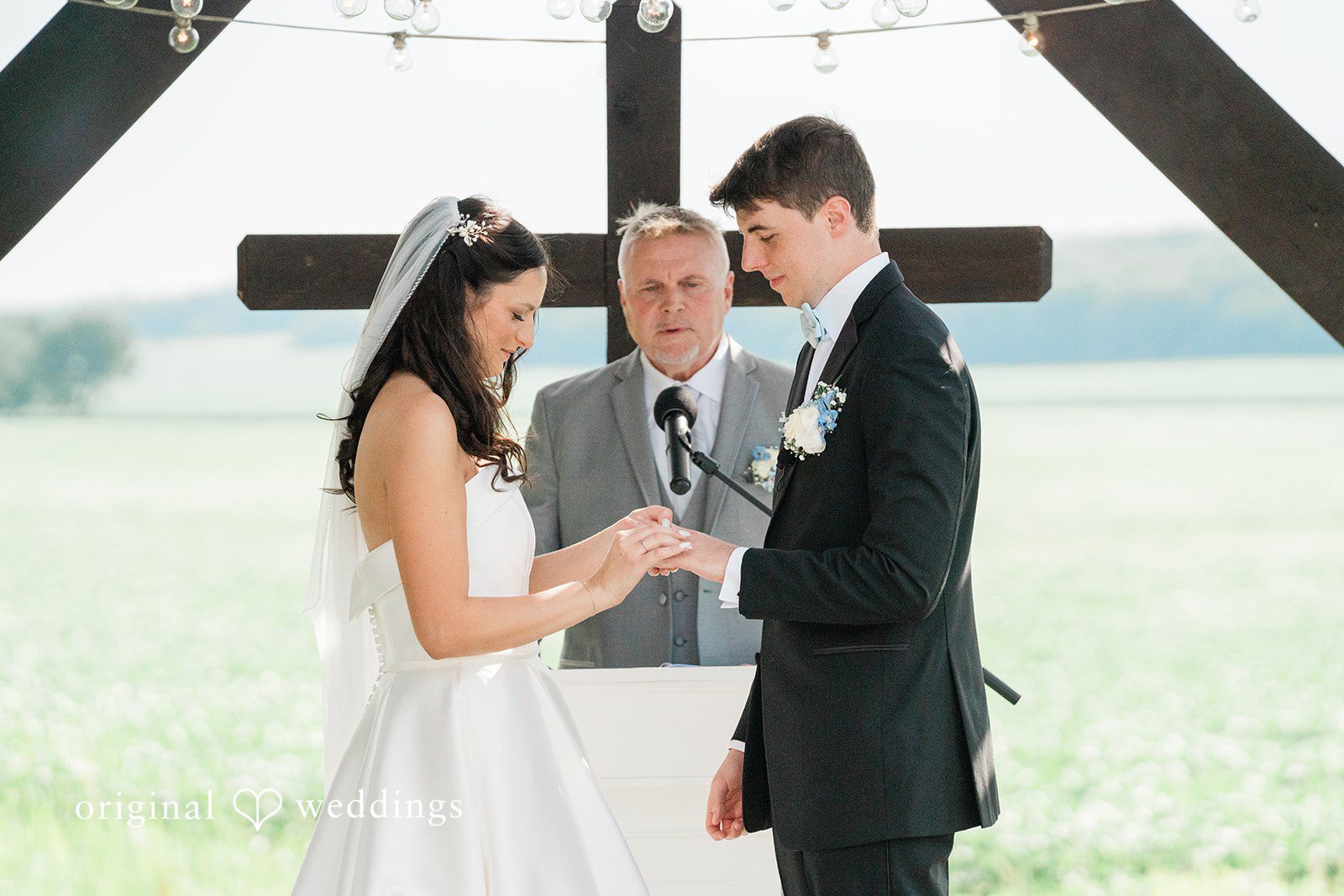 Paige + Stephen A bride and groom holding hands and exchanging rings.