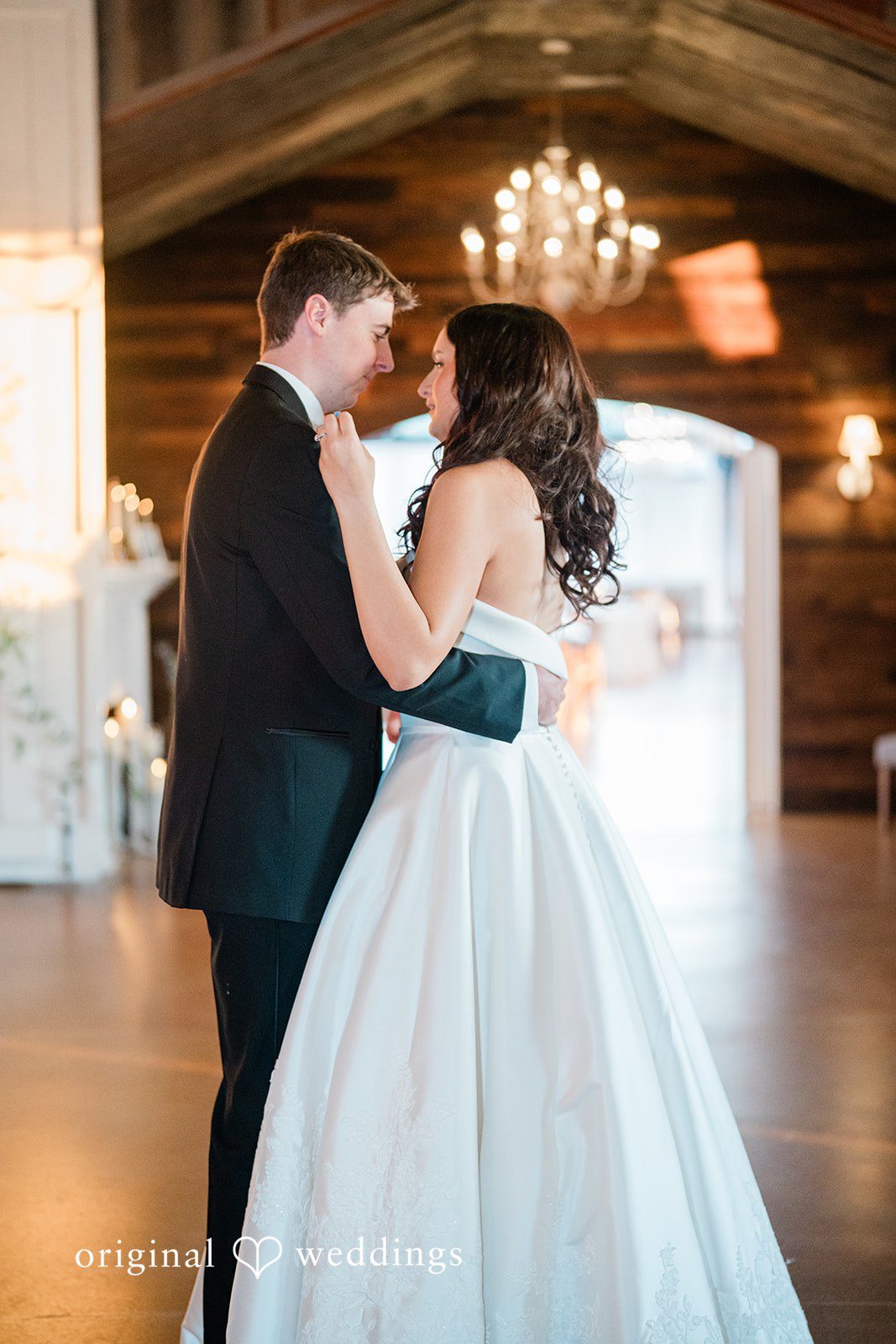 Paige + Stephen A bride and groom sharing a dance together on a wooden dance floor.
