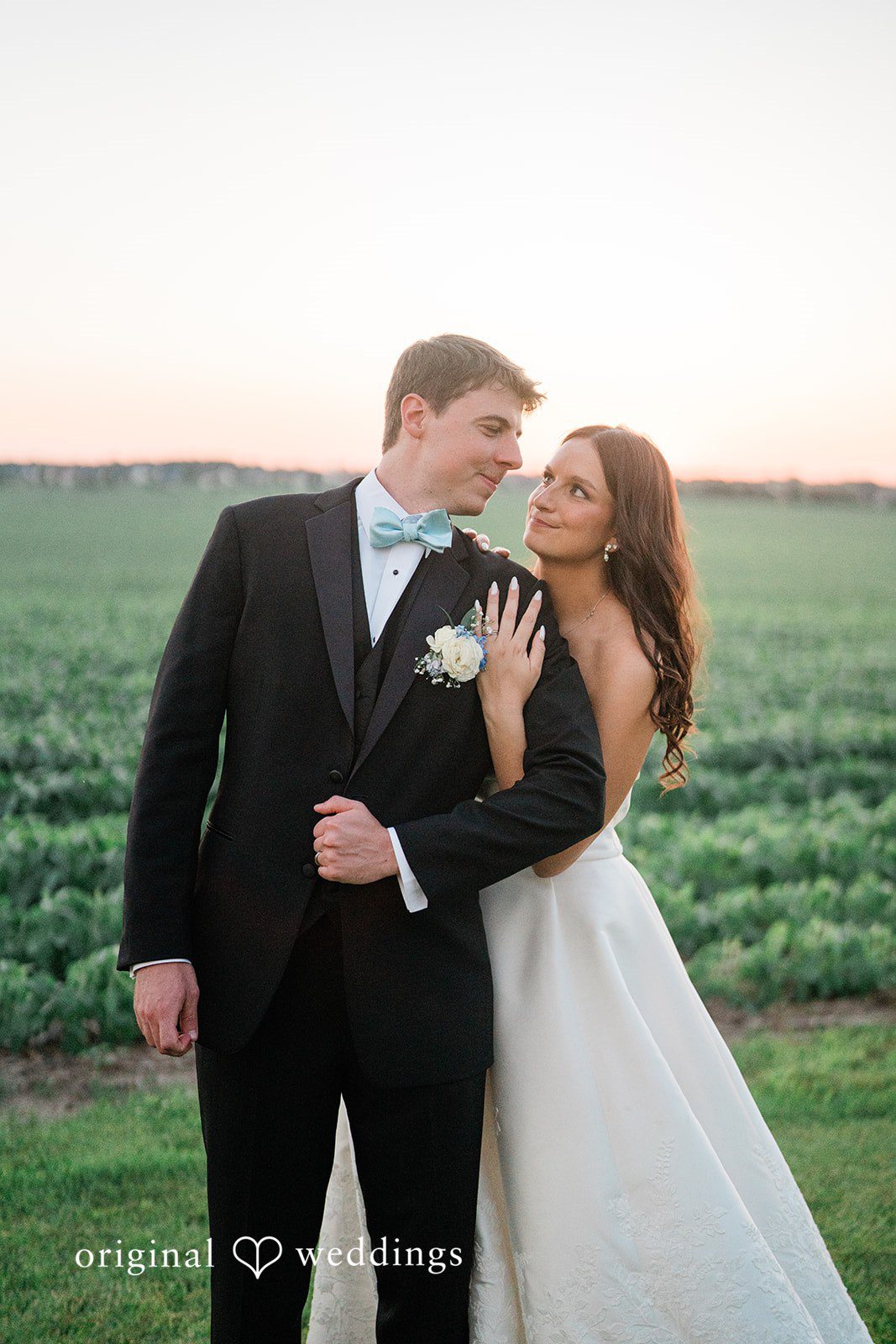 Paige + Stephen A groom in a black suit holding hands with a bride in a flowing white gown.