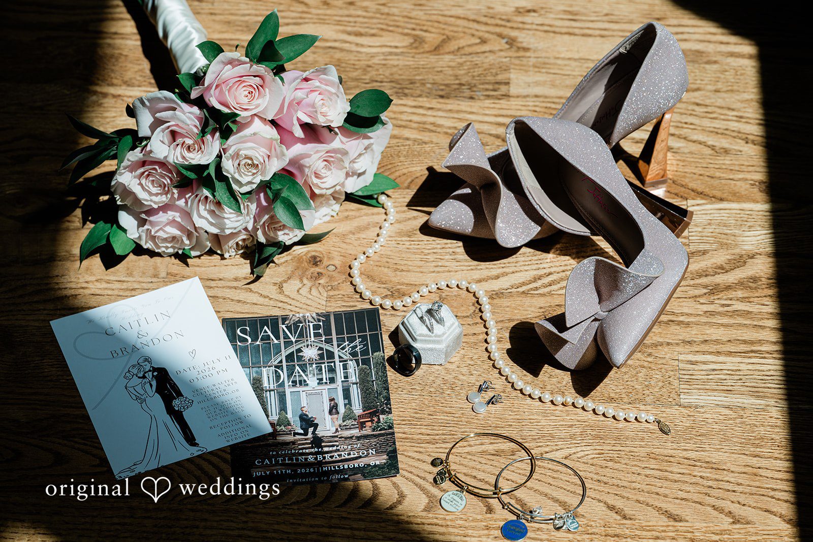 A flat-lay arrangement of groom accessories including shoes, a tie, and cologne on a dark surface.