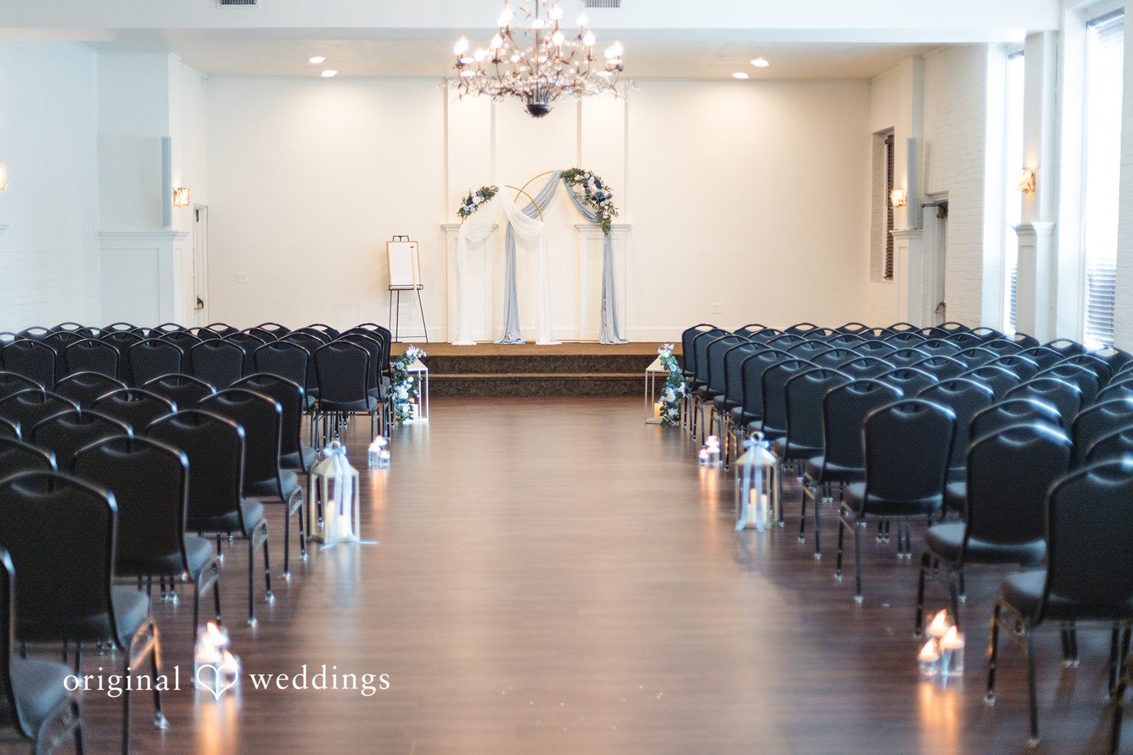Jaclyn + Mason Empty wedding ceremony aisle lined with dark chairs.