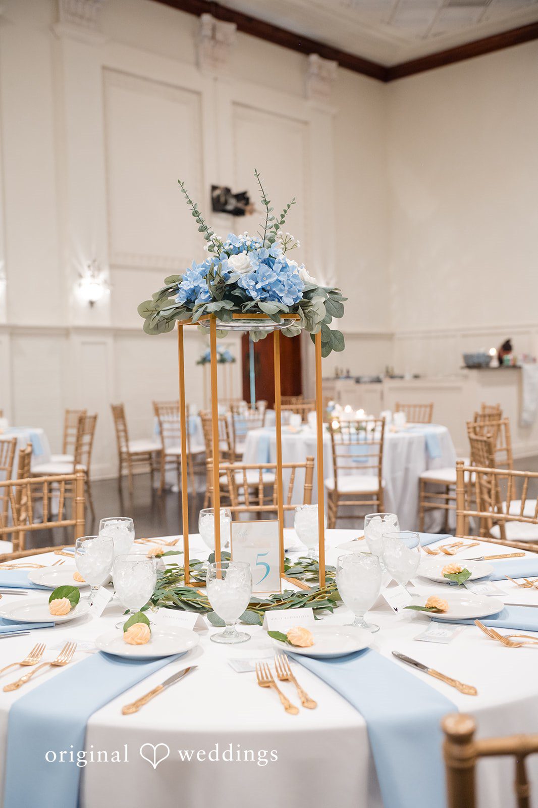 Jaclyn + Mason Round reception table with blue fabrics and floral centerpieces.