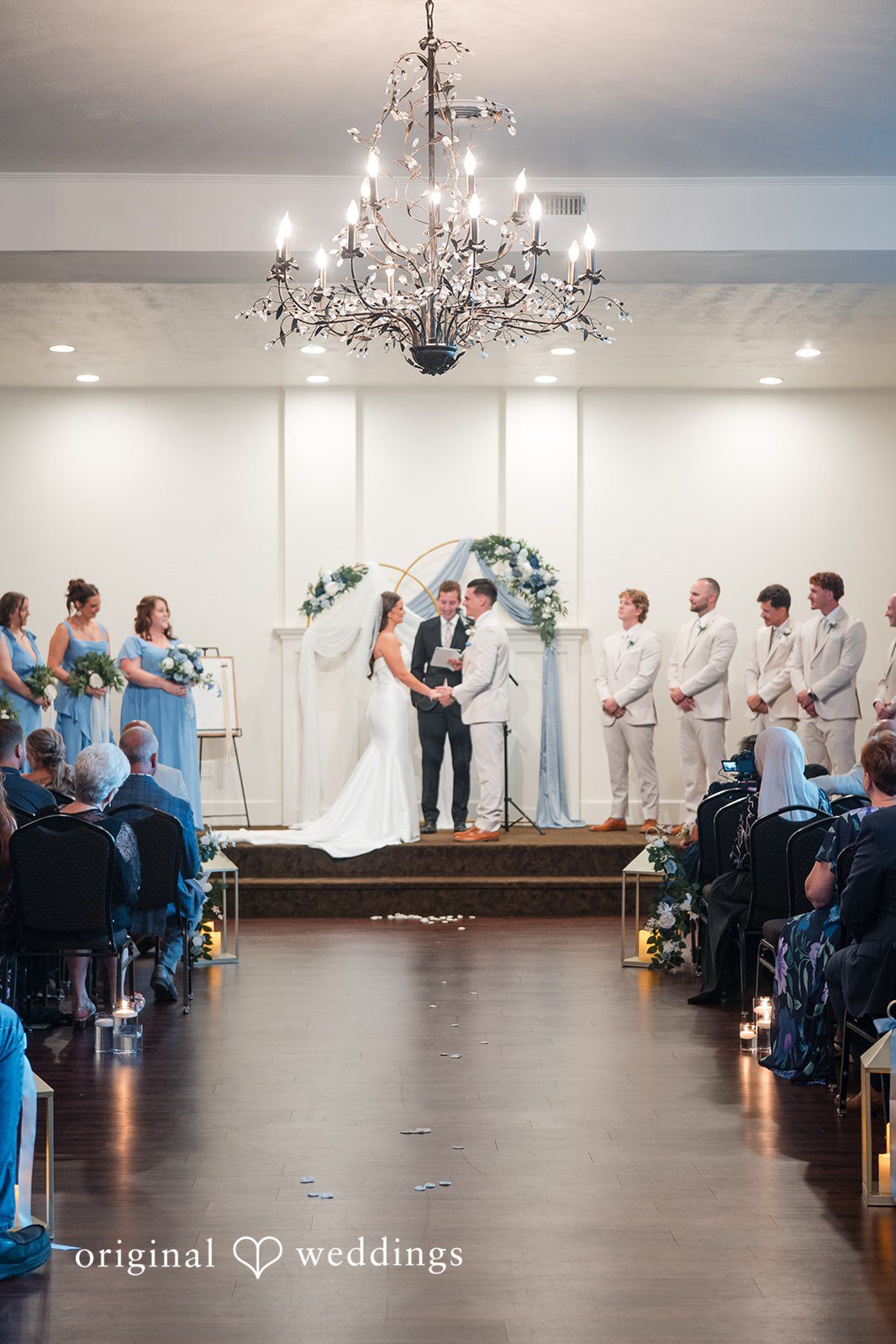 Jaclyn + Mason Wedding ceremony taking place in a crowded hall.