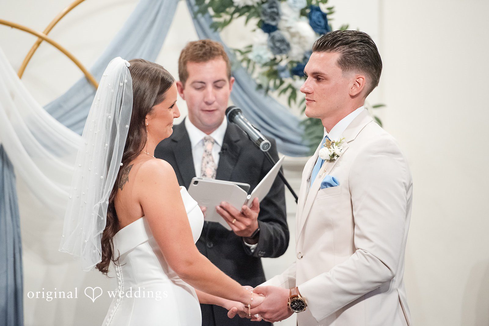 Jaclyn + Mason Bride and groom holding hands during their ceremony vows.