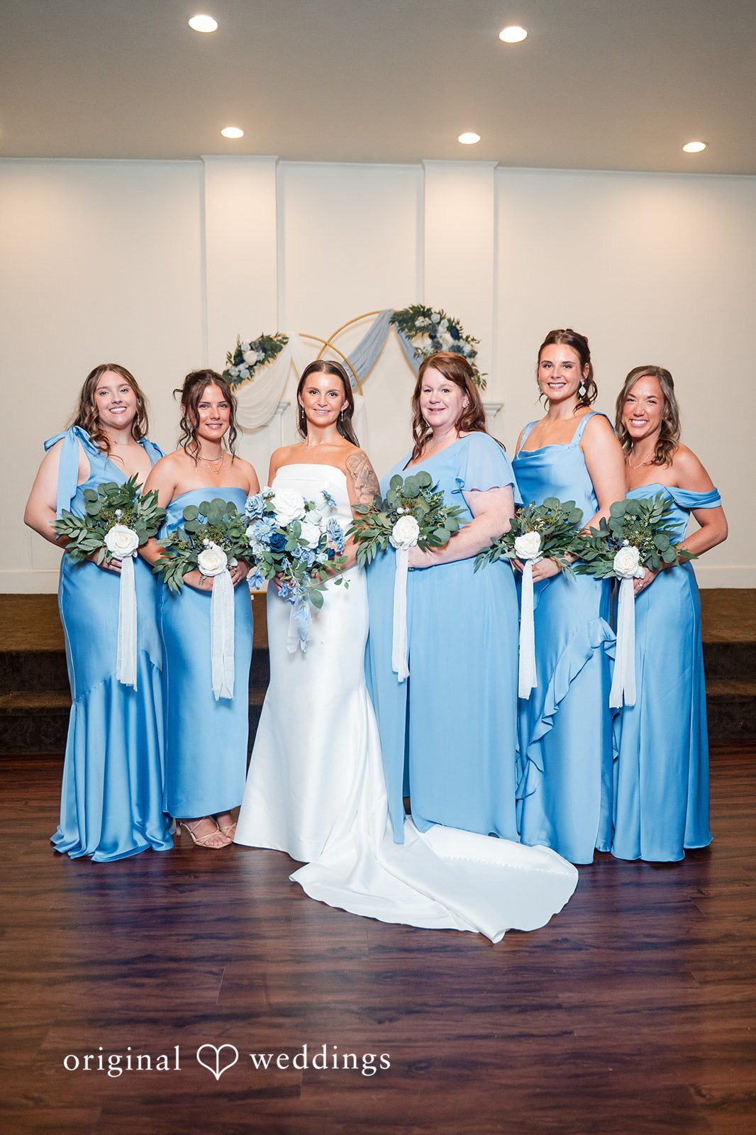 Jaclyn + Mason Bride posing alongside her bridesmaids in matching blue dresses.