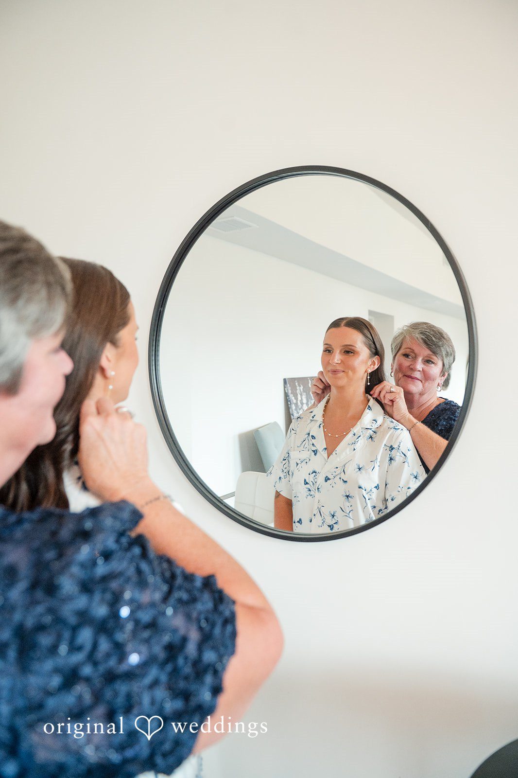 Jaclyn + Mason Bride looking into a round mirror reflecting her face.