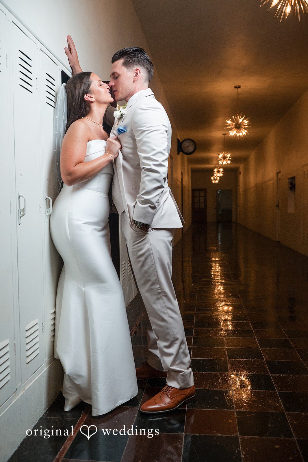 Jaclyn + Mason Bride and groom walking down a long lit hallway.