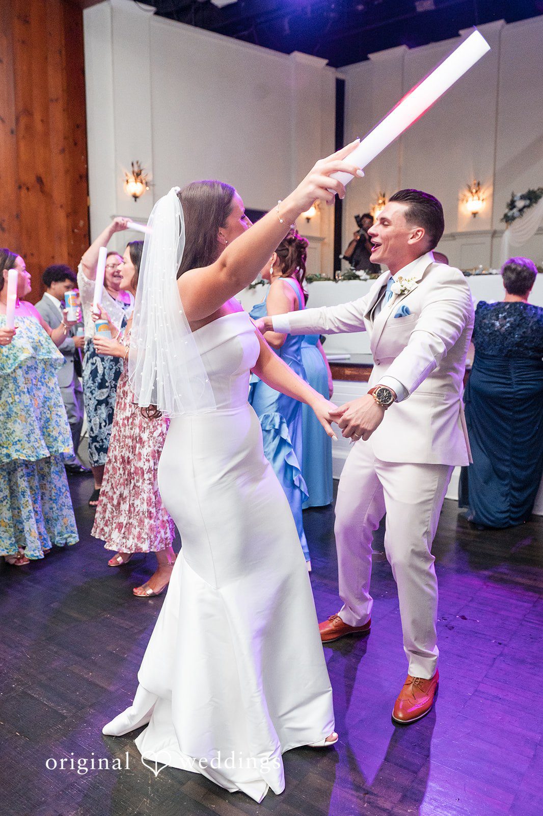 Jaclyn + Mason Bride dancing excitedly with a light-up foam stick.