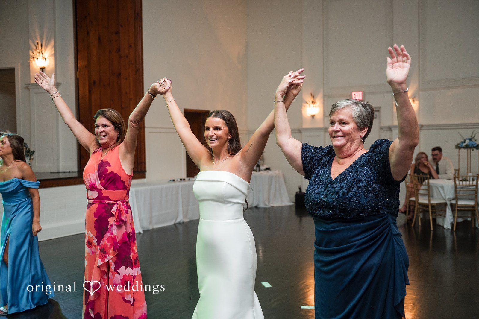 Jaclyn + Mason Three women dancing and waving their hands in the air.