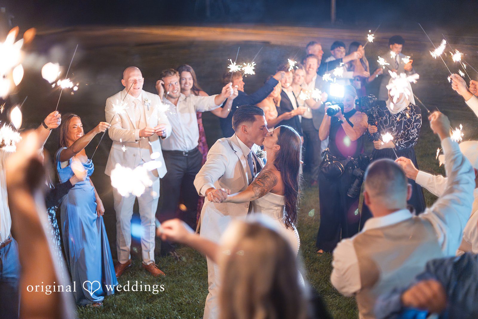 Jaclyn + Mason Wedding guests holding up sparklers during a nighttime exit.