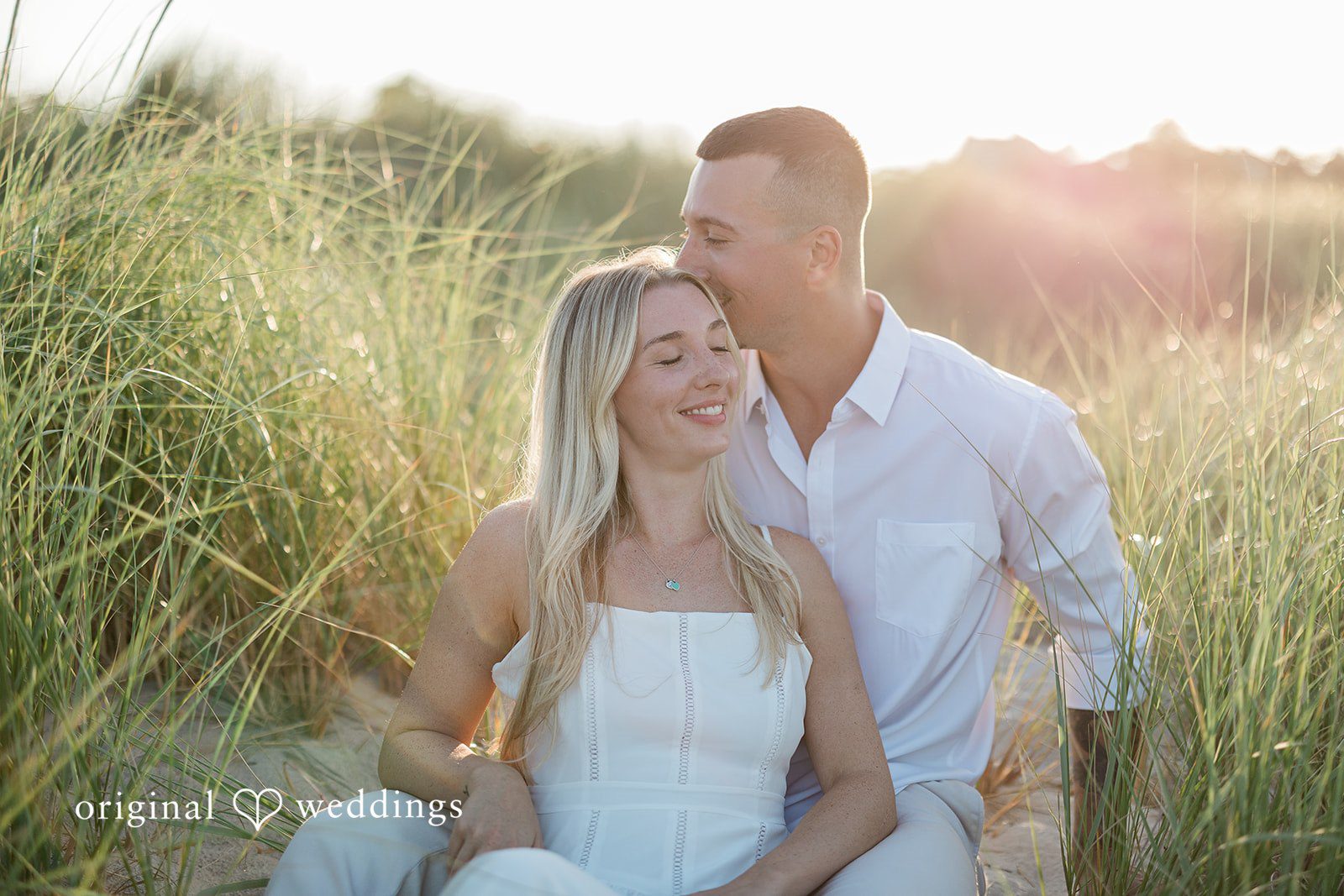 A close-up portrait of a smiling couple sitting close together.