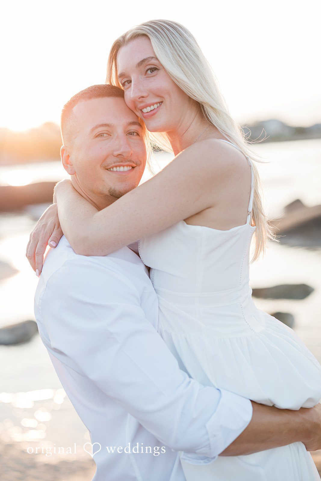 A man lifting and embracing a smiling woman.