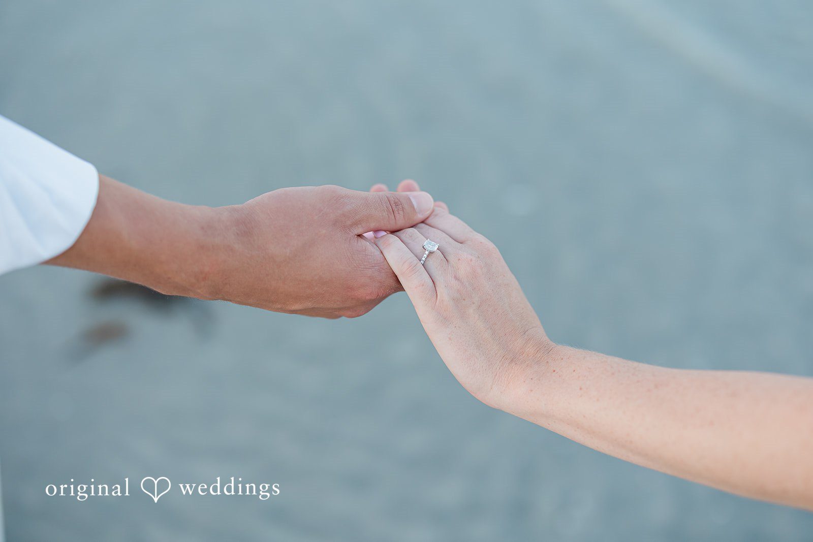 A close-up shot of two people holding hands.