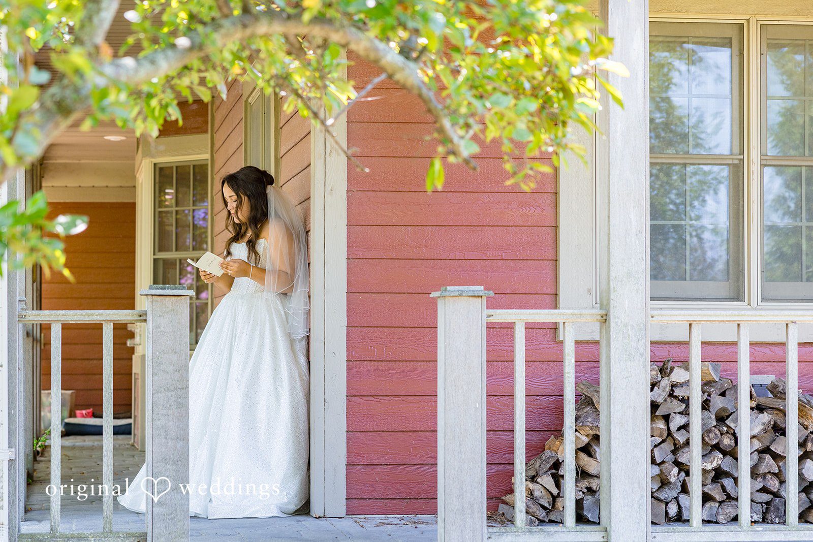 Melayna + Harley A bride in her gown stands near the entrance of a building.
