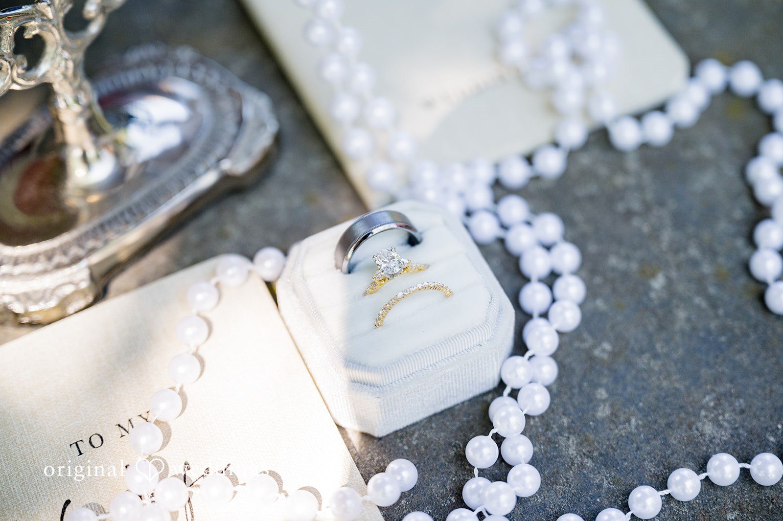Melayna + Harley A close-up captures black and white fabric details with a pearl necklace.
