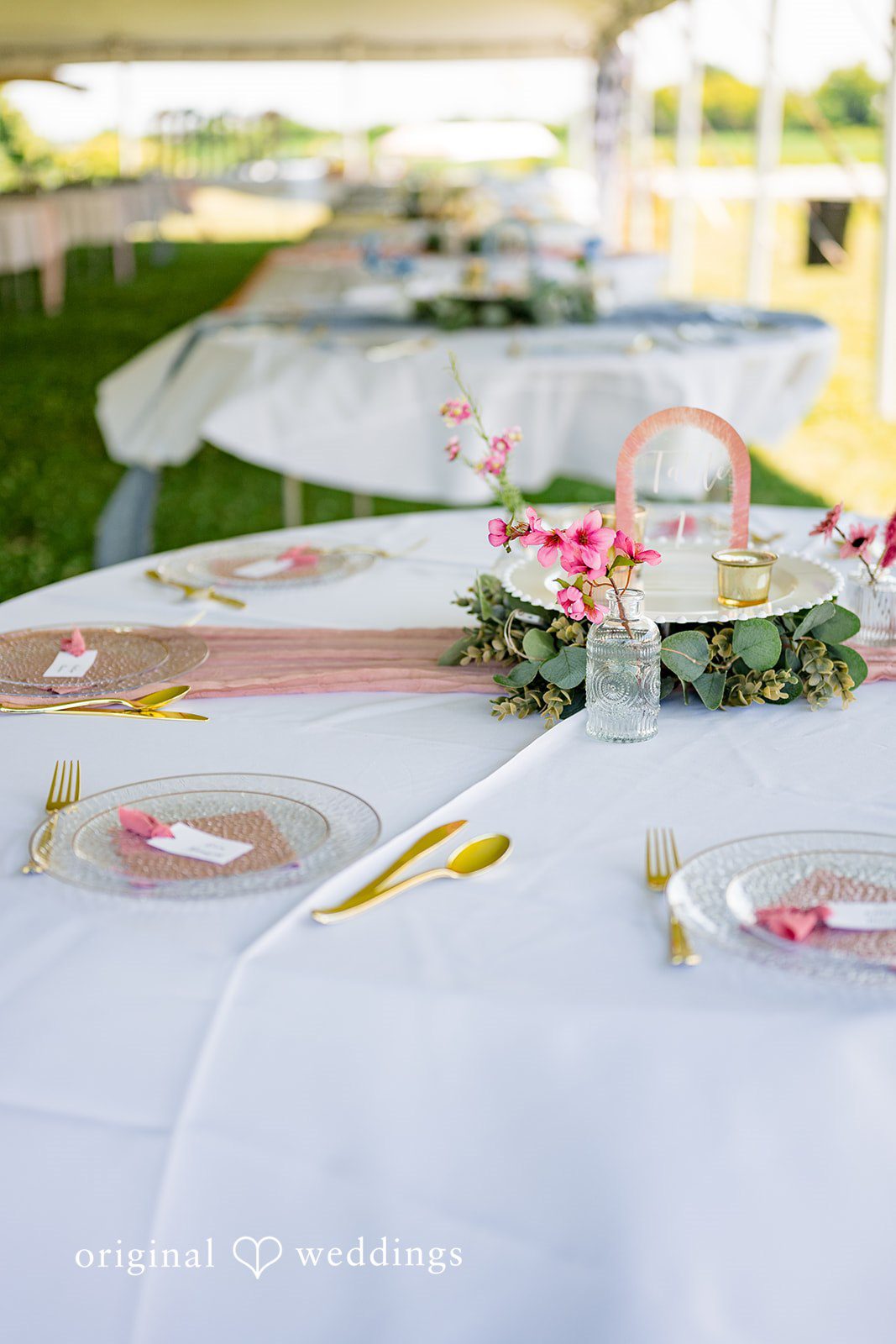 Melayna + Harley Table place settings are arranged with plates, greenery, and glassware.