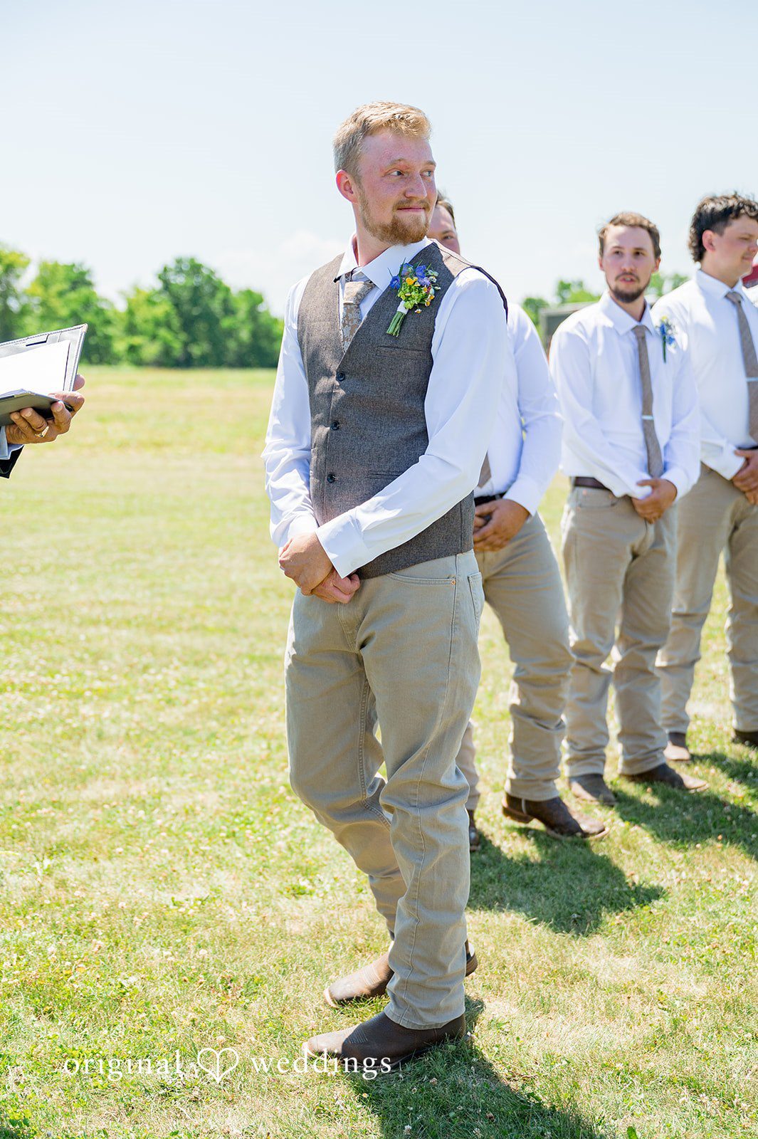 Melayna + Harley A groom and his groomsmen walk across a grassy lawn.
