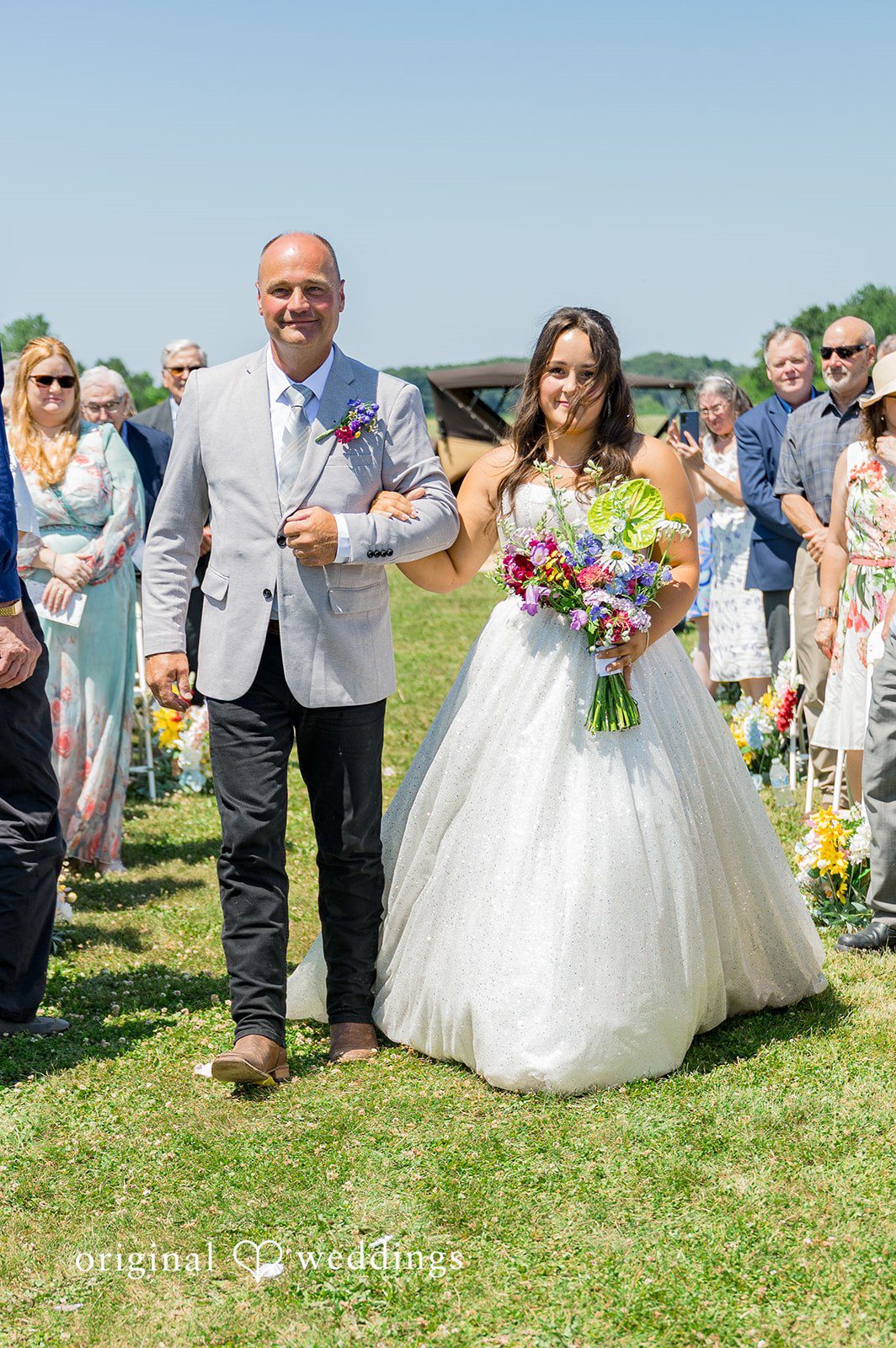 Melayna + Harley A bride and man walks together down a path.