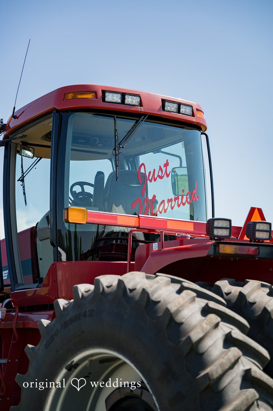 Melayna + Harley A close-up view shows the large rear tire and body of a red tractor.