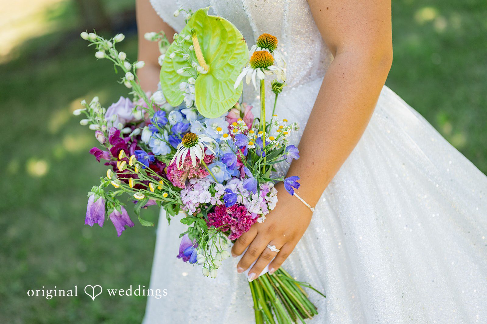 Melayna + Harley A close-up shows a bride holding a vibrant bouquet of wildflowers.