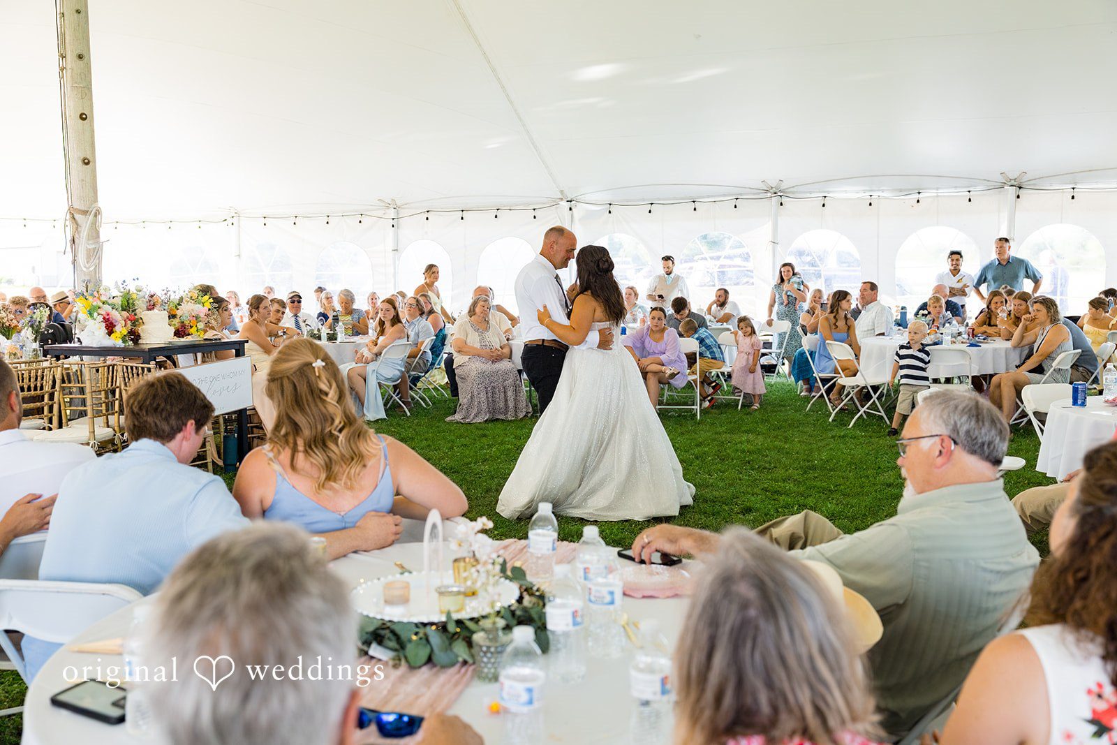 Melayna + Harley A bride and man share their first dance surrounded by guests.