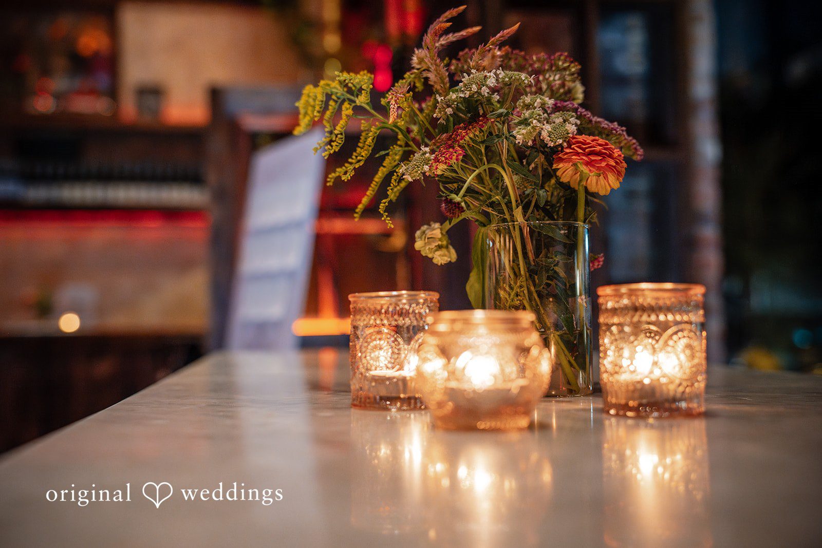 Claudio + Claire Candles and florals on the bar at Ainslie