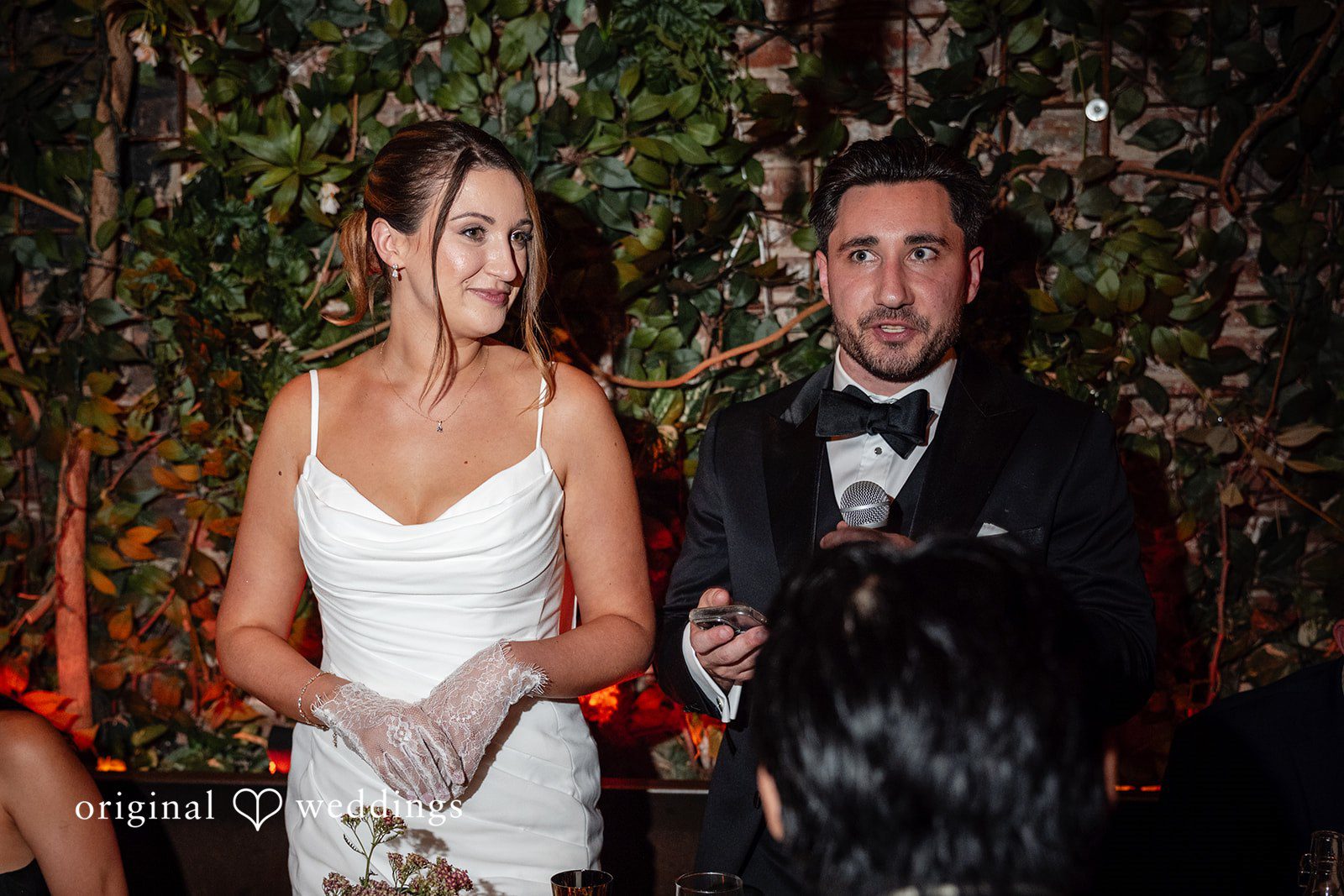 Claudio + Claire Claudio and Claire smiling together during toasts, captured by New York wedding photographers from Original Weddings at Ainslie