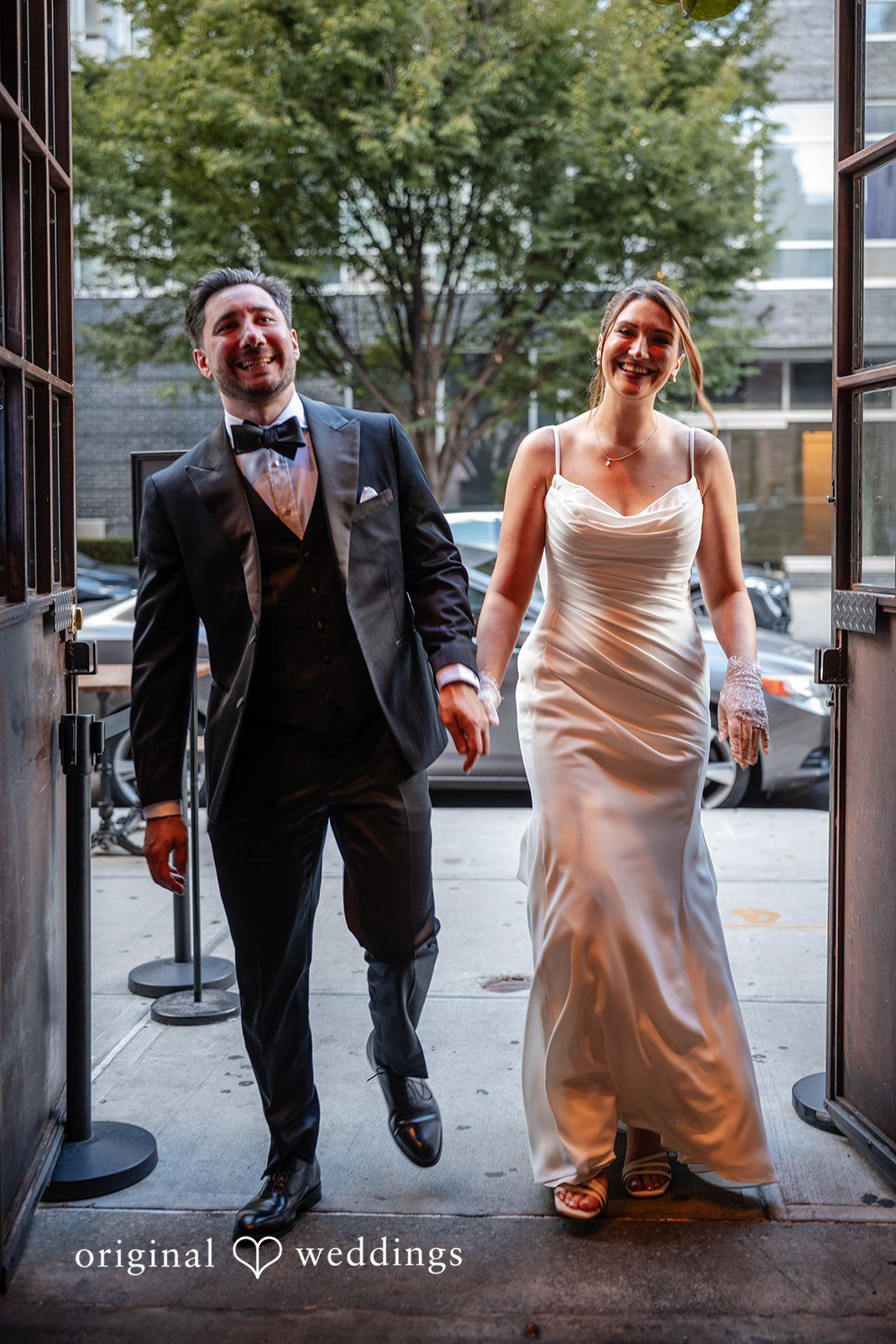 Claudio + Claire Claudio and Claire arriving through the doors, captured by New York wedding photographers from Original Weddings