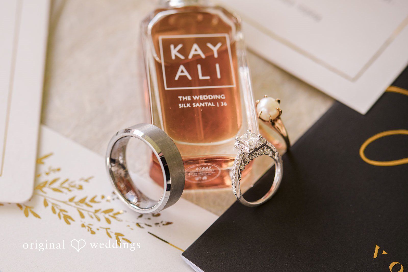 Emily + Angelo Detailed view of custom wedding invitation suites and a celebratory bottle.
