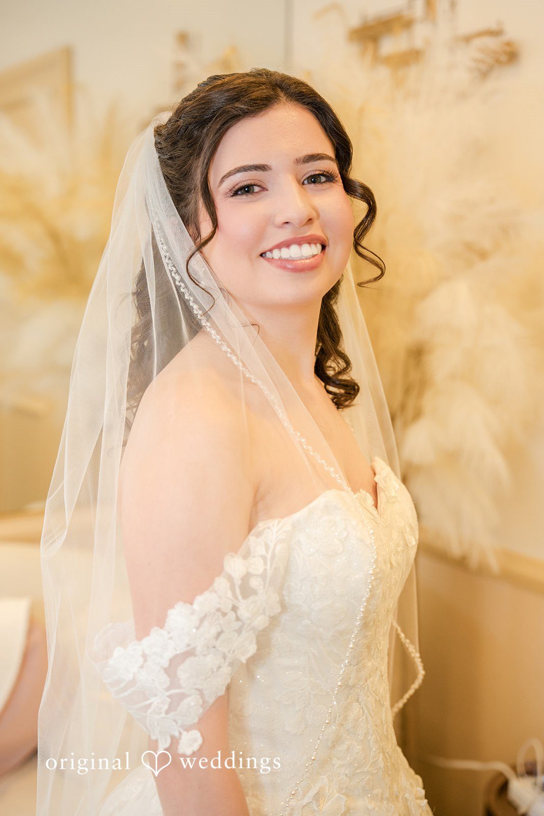 Emily + Angelo Smiling bride wearing a veil and a lace wedding dress.