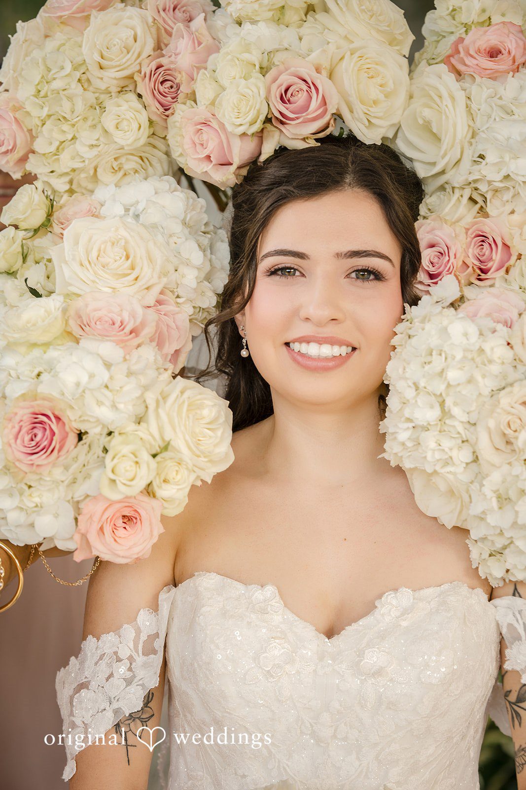 Emily + Angelo Close-up portrait of a smiling bride framed by lush white roses.