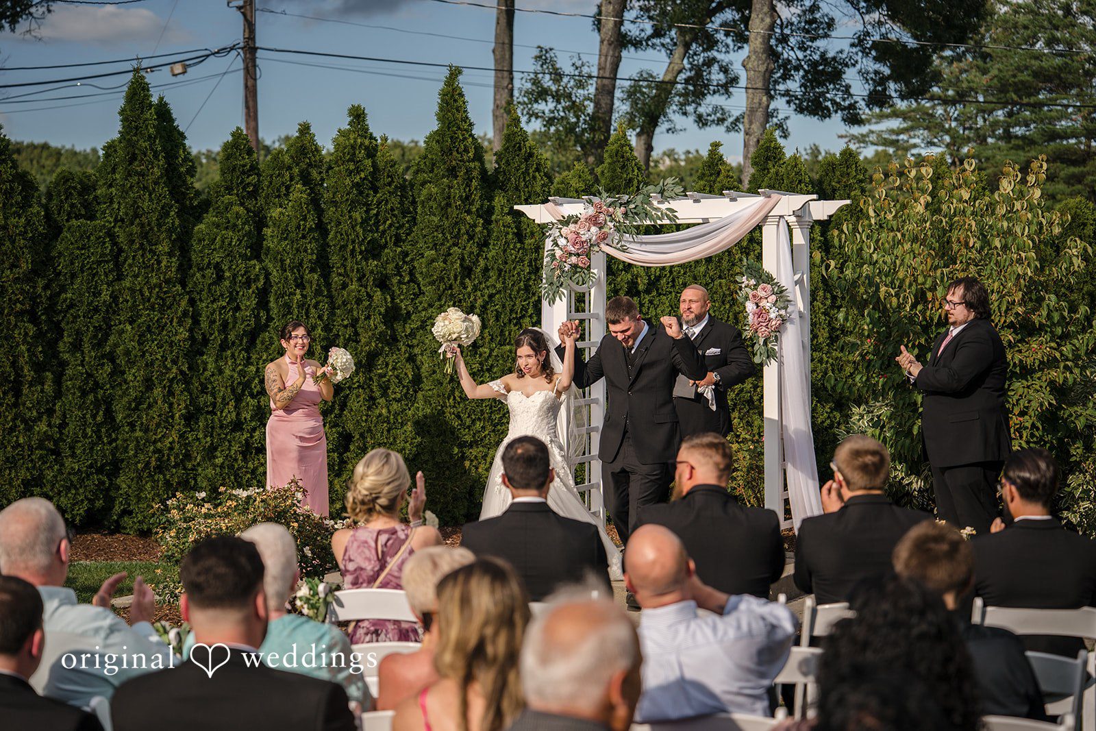 Emily + Angelo High-angle view of a wedding ceremony in progress with guests seated on a lawn.